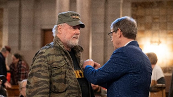Nebraska Governor Pillen pins a Vietnam War lapel pin on a Veteran of the Vietnam War.
