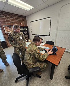 LTC Kristen Pouch, Commander, NCARNG RRB, looks on as MAJ Brandon Hough registers for PaYS