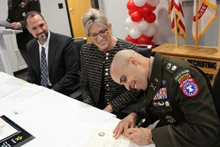 LTC Ramon Ramos signs the ceremonial Army PaYS certificate as Stacy Winsett and Jim Wojciechowski look on, marking the official launch of the partnership between RATP Dev USA and the U.S. Army. LTC Ramon Ramos signs the ceremonial Army PaYS certificate as Stacy Winsett and Jim Wojciechowski look on, marking the official launch of the partnership between RATP Dev USA and the U.S. Army.